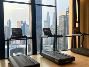 吉隆坡Axon Luxury Suites KL的窗户前有三个跑步机的健身房