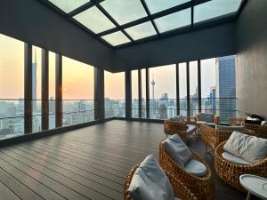 吉隆坡Axon Luxury Suites KL的大型客房设有桌椅和窗户。