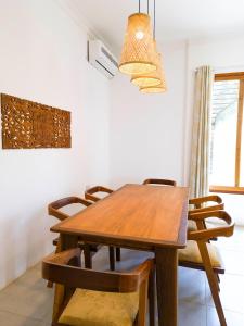 MaziziniThe Cliff 2 Bedroom Beach Apartment的一间带木桌和椅子的用餐室