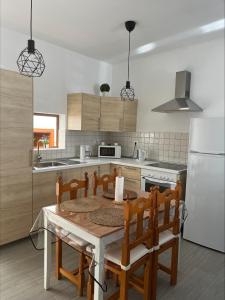 罗萨里奥港CASA LOS ABUELOS的厨房配有桌椅和白色冰箱。