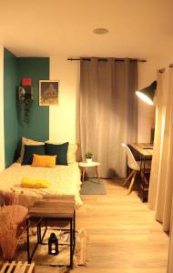 GagnyBeau studio proche gare的一间卧室配有一张床、一张桌子和一架钢琴