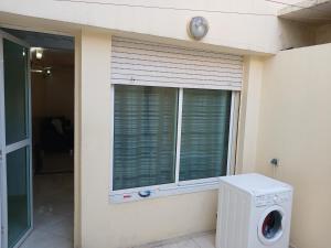 卡萨布兰卡Chambre privative dans un appartement partagé的窗户旁的洗衣机