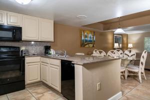 基西米Legacy Vacation Resorts Kissimmee & Orlando - Near Disney的厨房配有白色橱柜和桌椅