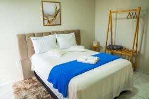 Serra de São BentoLoft vista da serra的一间卧室配有一张带蓝色毯子的大床