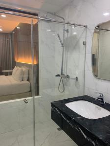 北标府Phurinda Residence的一间带水槽和玻璃淋浴的浴室
