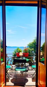韦尔巴尼亚Casa Gambusso historical house magnificent Lake View的阳台配有桌椅,享有风景。