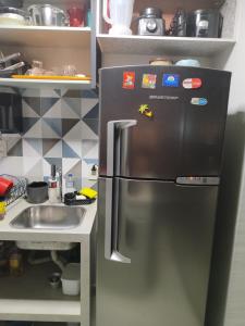 塔瓜汀加Taguá life apartamento amplo moderno e encantador的厨房里配有不锈钢冰箱,设有水槽