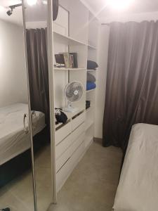 塔瓜汀加Taguá life apartamento amplo moderno e encantador的一间卧室配有一张床和一个带风扇的衣柜