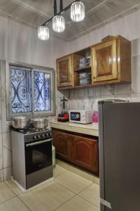 杜阿拉Meuble Modon Nyalla的厨房配有木制橱柜和炉灶烤箱。