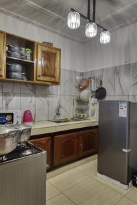 杜阿拉Meuble Modon Nyalla的厨房配有木制橱柜和不锈钢冰箱。