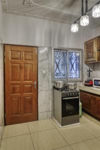 杜阿拉Meuble Modon Nyalla的一间带炉灶和木门的厨房