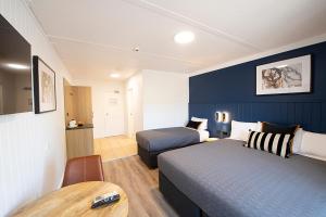 悉尼Southend Hotel的酒店客房设有两张床和一张桌子。