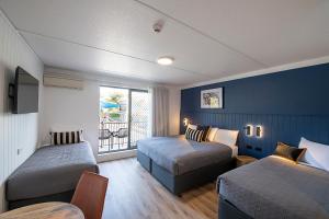 悉尼Southend Hotel的酒店客房设有两张床和窗户。
