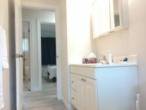 埃德蒙顿Sweethome - 10 min to Rogers Place & so much more的白色的浴室设有水槽和镜子