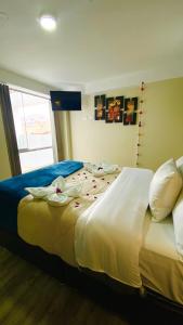 库斯科Hotel Valle Andino的一间卧室配有一张带鲜花的大床