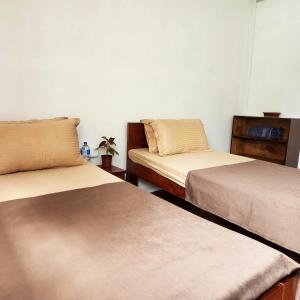 BeniThe Heritage at Lamakhet Hotel的一间设有两张床和一张桌子的房间