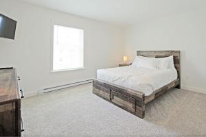 奥本Idyllic & Cozy Stylish Belmont Haven near Lewiston - 1BR 1BA Apartment的一间白色卧室,配有床和电视