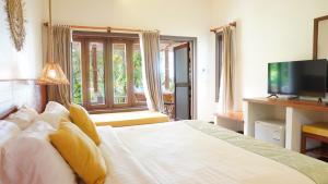 高兰Treeya Lanta的卧室配有白色的床和电视。