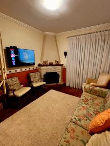 坎波斯杜若尔当Apartamentos Centrinho Capivari - Condomínio Recanto do Boticário的客厅设有壁炉和电视。