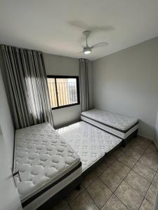 瓜拉派瑞Apto Completo com 03 Quartos e Wifi 600mbps的带窗户的客房内的两张床