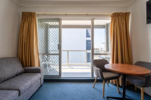 麦夸里港阿罗哈港口汽车旅馆的带沙发、桌子和窗户的客厅