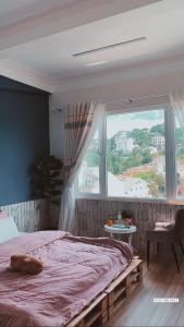 大叻Hằng Nga Villa的一间卧室设有一张床和一个大窗户