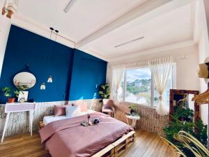 大叻Hằng Nga Villa的一间拥有蓝色墙壁和一张大床的卧室