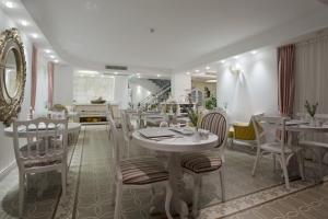 塞尔丘克塞拉艾弗斯酒店&SPA的一间设有白色桌椅的用餐室