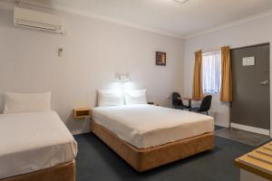 麦夸里港阿罗哈港口汽车旅馆的酒店客房配有两张床和一张书桌