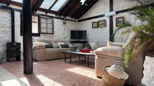 TanqueCASA MARA Casa Rural con terraza, barbacoa y vistas al Teide的带沙发、桌子和电视的客厅