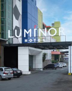 万隆Luminor Hotel Metro Indah - Bandung by WH的停车场内停车的酒店标志