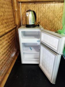 高兰Palm Garden Bungalows的开放式冰箱的顶部配有茶壶
