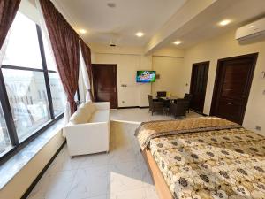 伊斯兰堡Motorway Majesty Suites Islamabad - Near Islamabad International Airport and Motorway的一间卧室配有一张床、一张沙发和一张桌子