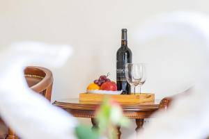 大叻Villa Hoa Ly Đà Lạt的一瓶葡萄酒和一碗水果放在桌子上