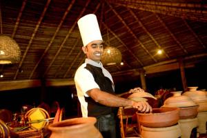 卡尔皮蒂耶Palagama Beach Resort的站在陶器旁的厨师帽子上的人