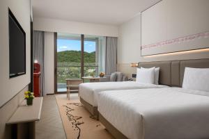 三亚三亚亚龙湾星华华邑度假酒店（首日迷你吧免费）的酒店客房设有两张床和电视。