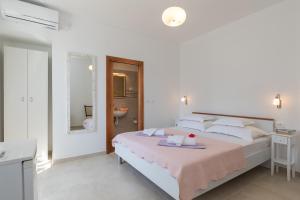 杜布罗夫尼克guesthouse Libertas 1的白色卧室配有一张带粉色毯子的床