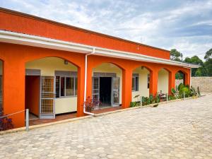 KihihiNB MOTEL-KIHIHI的一座橙色和白色的建筑,设有庭院