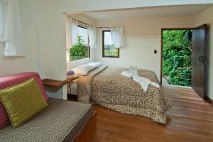 蒙泰韦尔德哥斯达黎加The Cloud Forest Magical Villa的一间带两张床和一张沙发的卧室