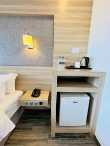马富施卡尼格兰德海景旅馆的小房间设有一张床和一张带电话的书桌