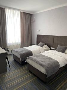 巴尔喀什Жемчужина гостиница Балхаш的酒店客房设有两张床和窗户。