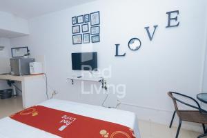 加拉旺Redliving Apartemen Grand Sentraland - AT Properti Tower Pink的白色的客房设有一张床和墙上的电视