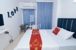 加拉旺Redliving Apartemen Grand Sentraland - AT Properti Tower Pink的酒店客房,配有一张红色领带的床