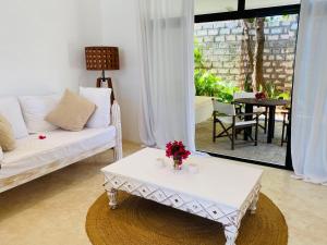 瓦塔穆Nyumba Nyekundu的客厅配有白色的沙发和桌子
