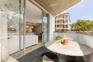 悉尼Bondi Oasis: 2BR + Balcony Bondi Beach的用餐区设有桌子和玻璃墙