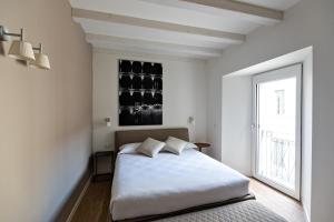 多莫多索拉Palazzo 7的白色的卧室设有床和窗户