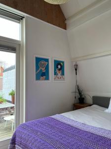 阿尔克马尔Groenlokaal的一间卧室配有一张带紫色床单的床和窗户。