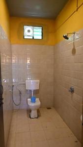戈卡尔纳Trippr Gokarna - Beach Hostel的一间带卫生间和淋浴的浴室以及窗户。