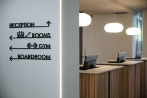 摩德纳RMH Modena Raffaello的带有指示牌的办公室,可读到接待室和健身房