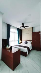 富国Xan hotel Phu Quoc的一间卧室配有一张带吊扇的床